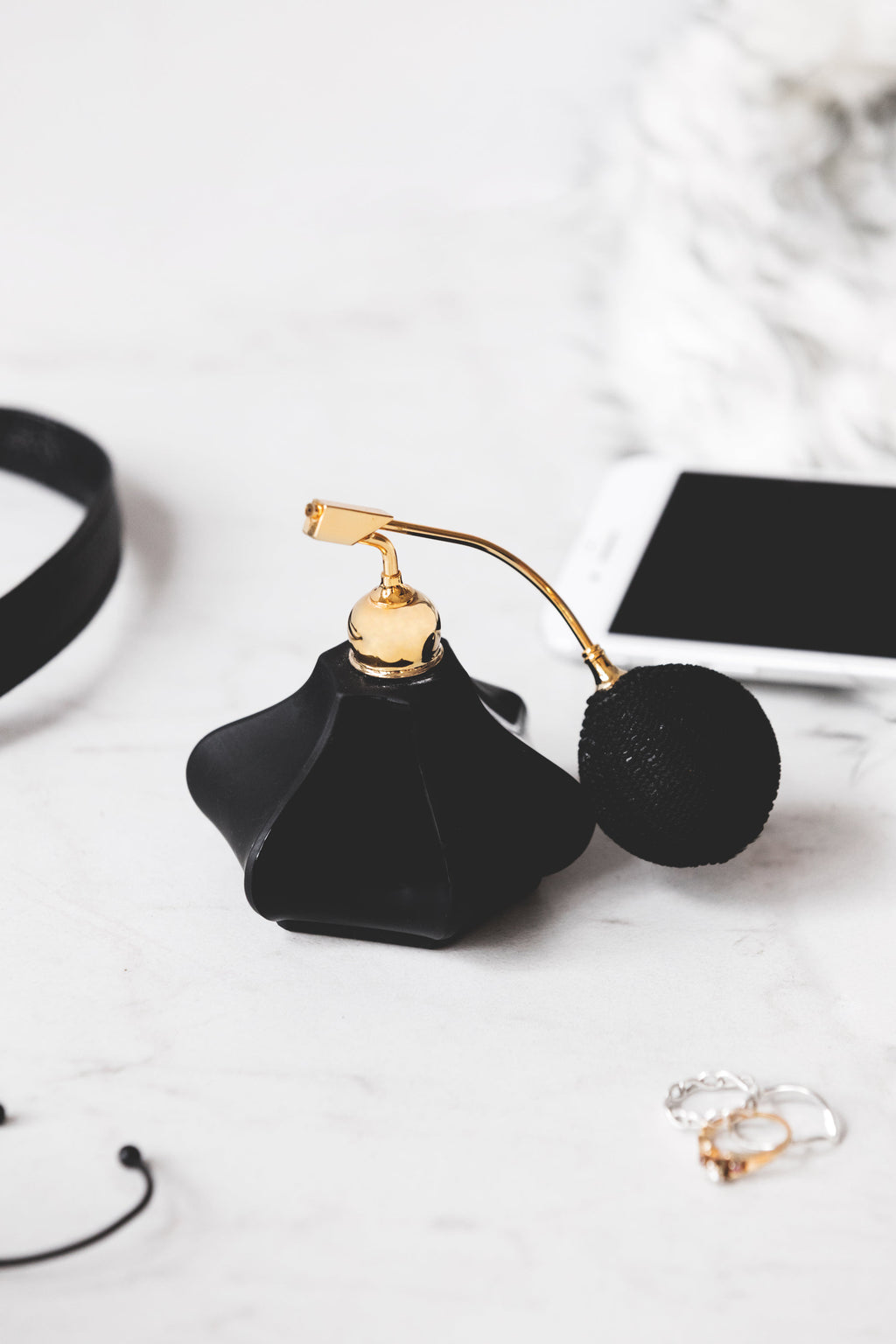 Flacon de parfum noir à poire dorée, vue rapprochée