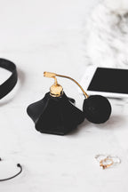 Flacon de parfum noir à poire dorée, vue rapprochée