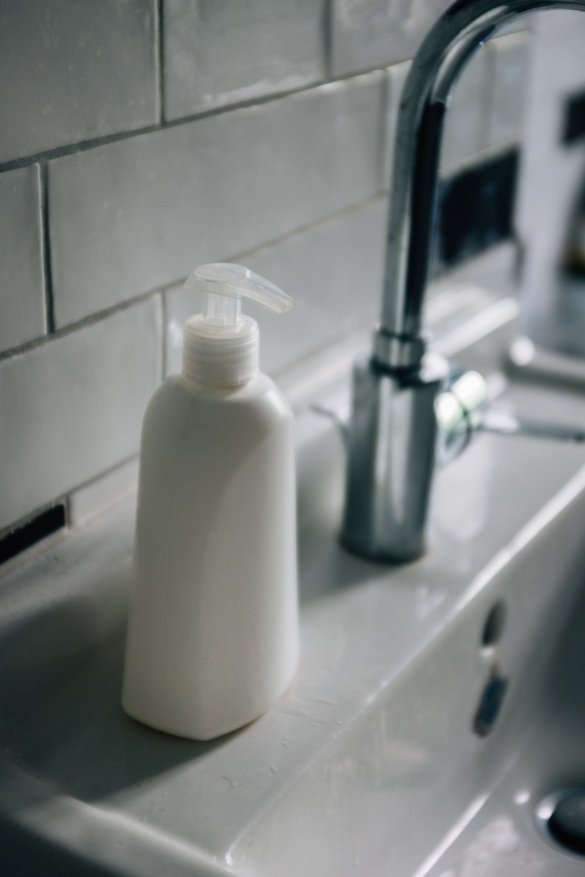 Flacon pompe blanc sur un lavabo